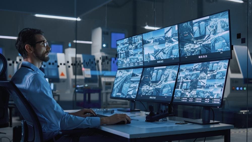 Security officer reviewing CCTV screens in a Glasgow office.